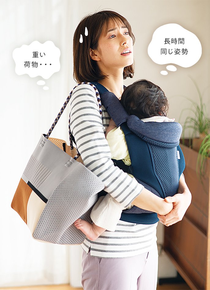 写真:赤ちゃんを抱っこしながら、右肩で鞄を持っている女性の様子