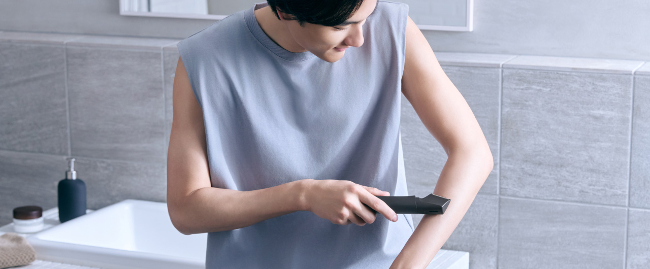 写真：腕ににボディトリマーを使用している様子