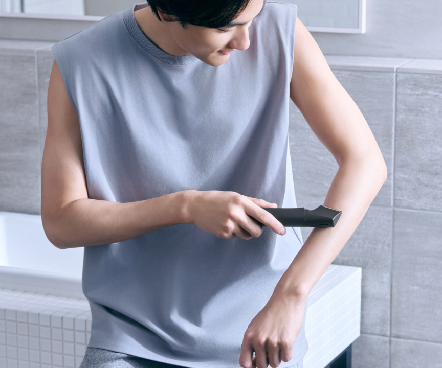 写真：腕ににボディトリマーを使用している様子