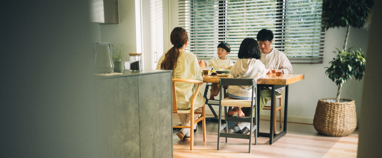写真：ダイニングテーブルでの家族4人の食事風景
