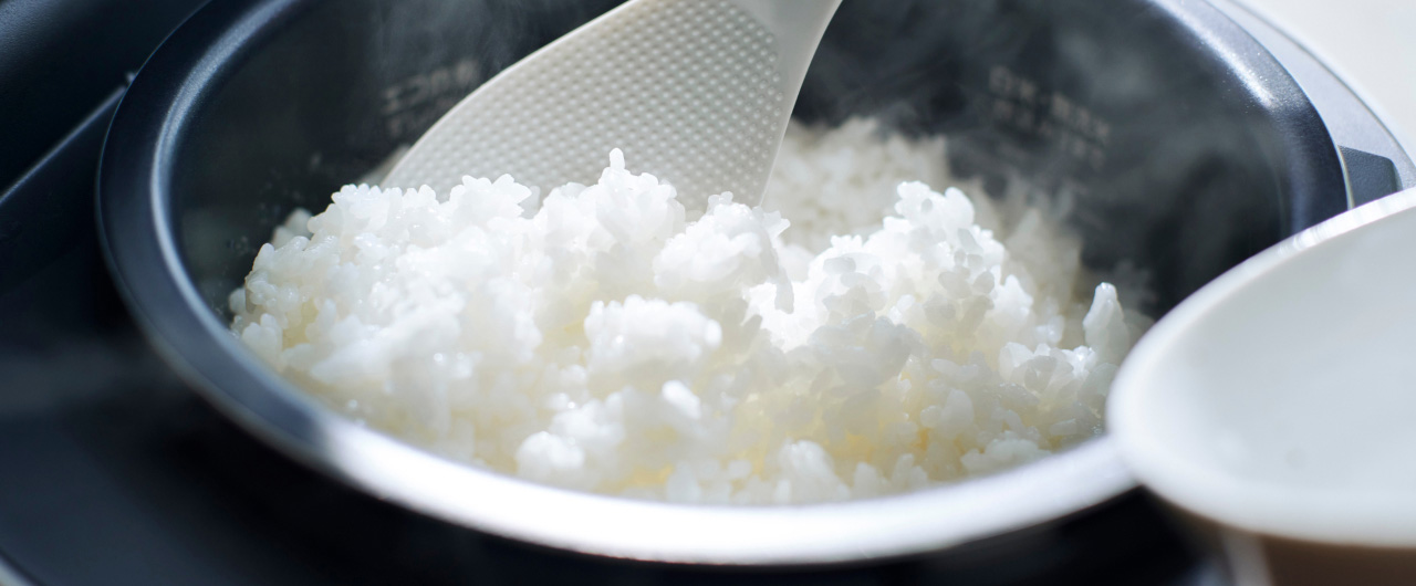 写真：炊飯器で炊き上がった白ご飯をしゃもじですくう様子