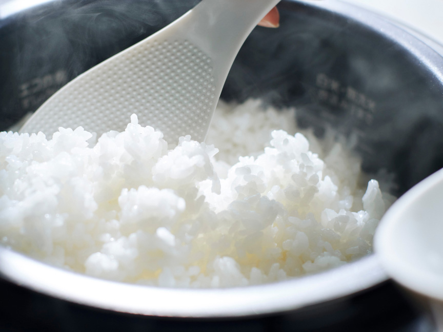 写真：炊飯器で炊き上がった白ご飯をしゃもじですくう様子