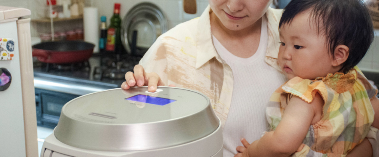 赤ちゃんを片手で抱っこしながら家事をしている様子