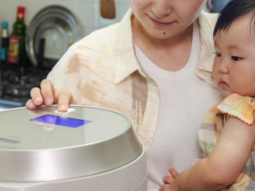 赤ちゃんを片手で抱っこしながら家事をしている様子