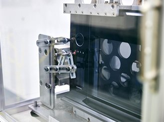 写真:スチームオーブンレンジの液晶の操作部・操作ボタンを、機械で押している様子