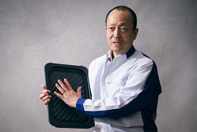 写真:明⽯孝之さんが右手にヒートグリル皿を持っている様子