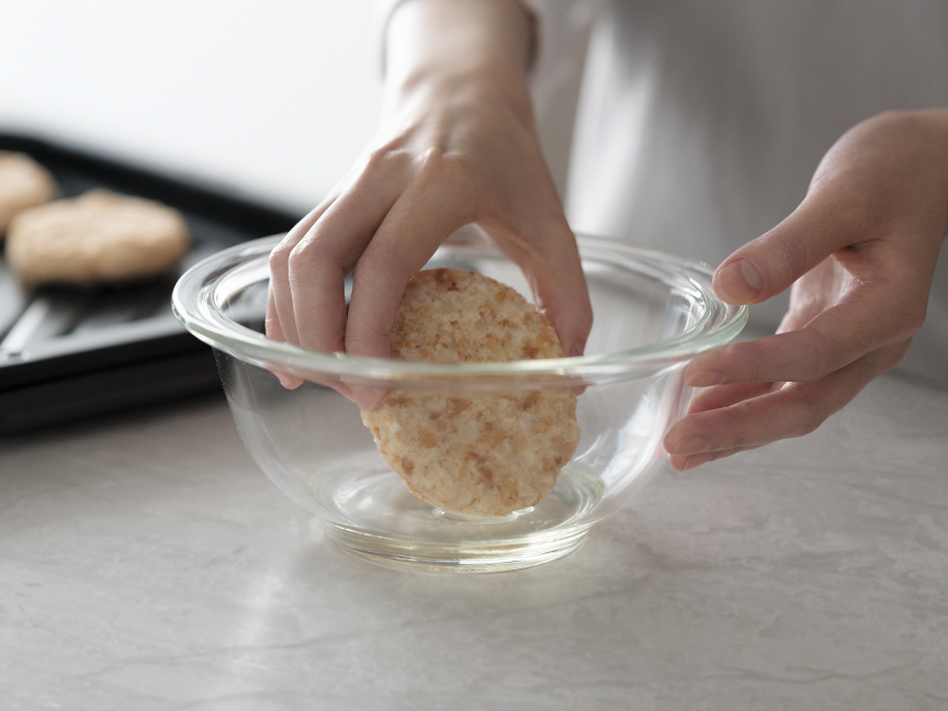 ボウルに入れた油を、冷凍フライに付けている様子。