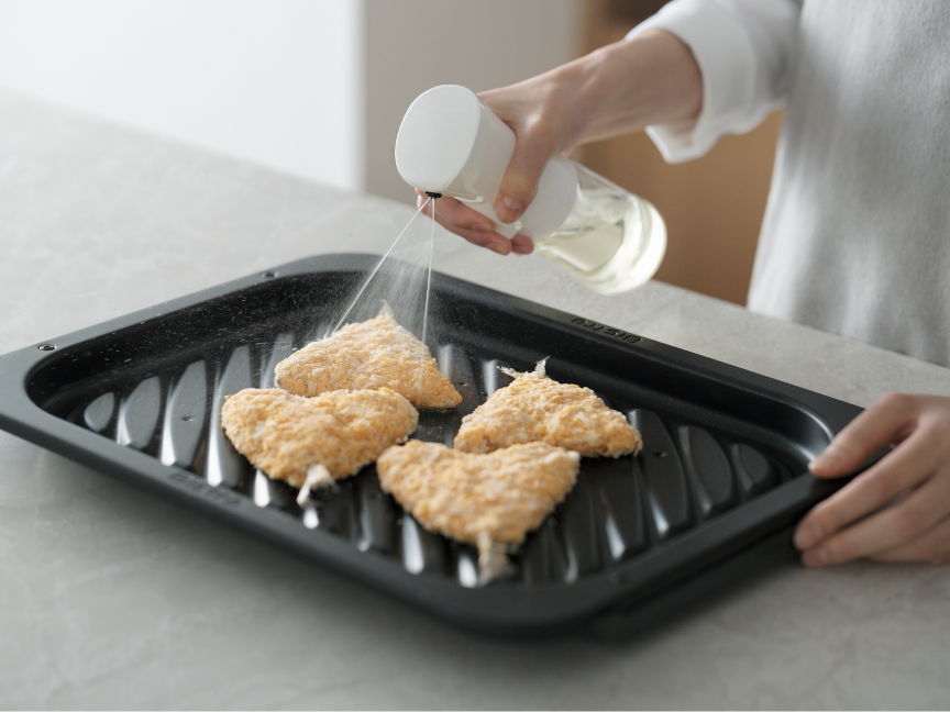 冷凍フライに油を吹きかけている様子。