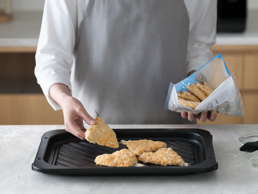 冷凍フライをヒートグリル皿に並べている様子。