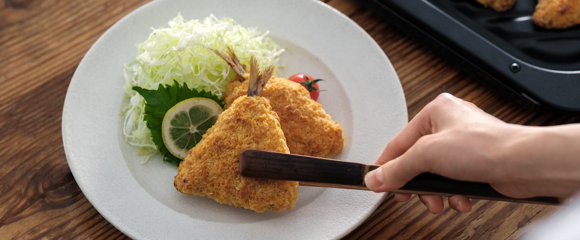 「おまかせ熱風フライ」のメインビジュアルです。あじフライを盛り付けている様子です。