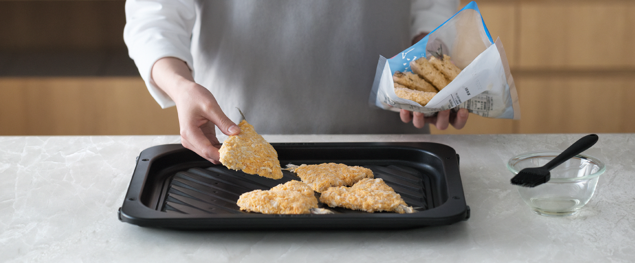 冷凍フライをヒートグリル皿に並べている様子。