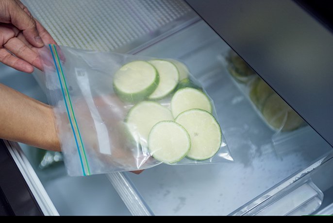 写真：フリーザーバッグを冷凍室に入れる様子