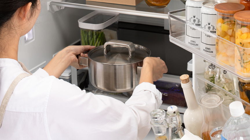 画像：女性が冷蔵室に鍋を入れているシーン
