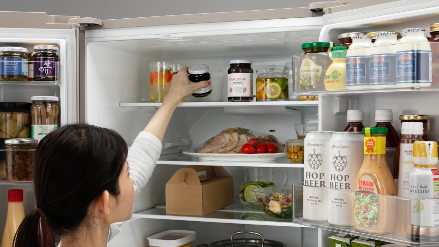 画像：女性が冷蔵室最上段の食材を取ろうとしている様子
