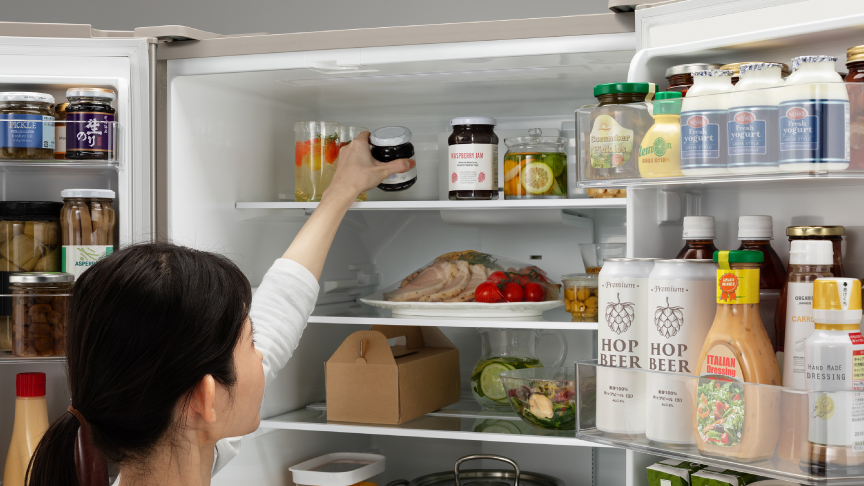 画像：女性が冷蔵室最上段の食材を取ろうとしている様子