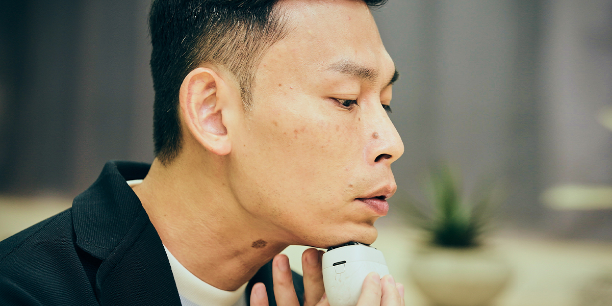 写真：今井 裕平さんがラムダッシュパームインを顎に当てている様子