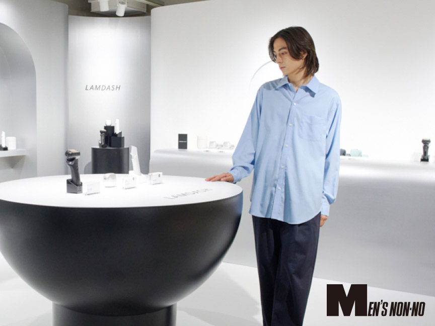 写真：ラムダッシュ特設ルームで、松岡光さんが展示テーブルを見ている様子  MEN'S NON-NO
