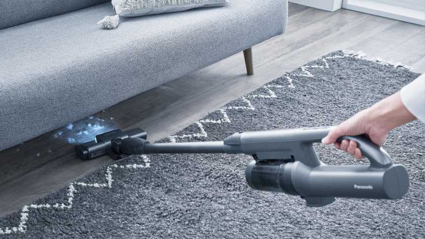 家具下などの暗いところもLEDライトで照らして掃除している様子