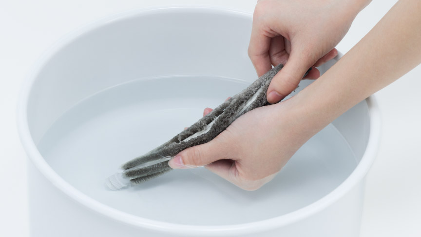 写真：ブラシを水洗いする様子