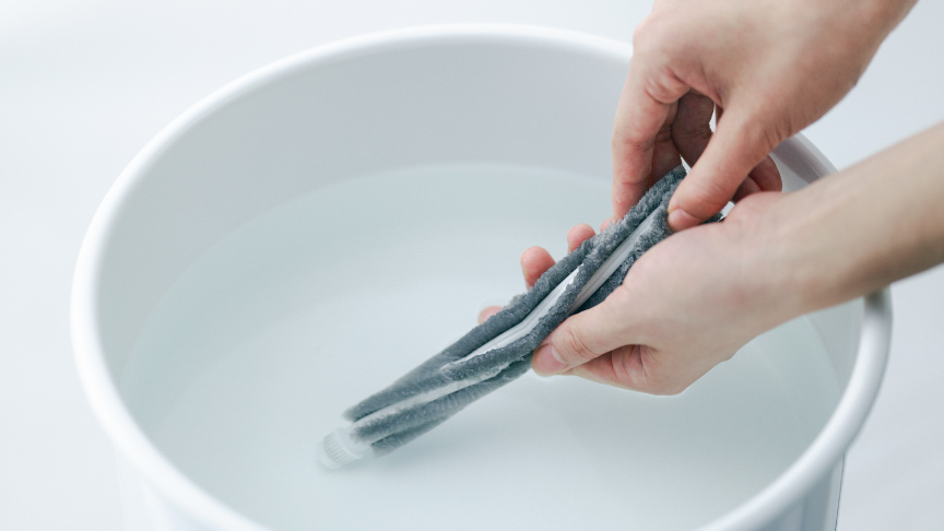 写真：ブラシを水洗いする様子