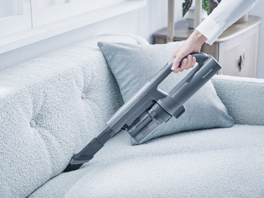 写真：ソファのすき間を掃除する様子