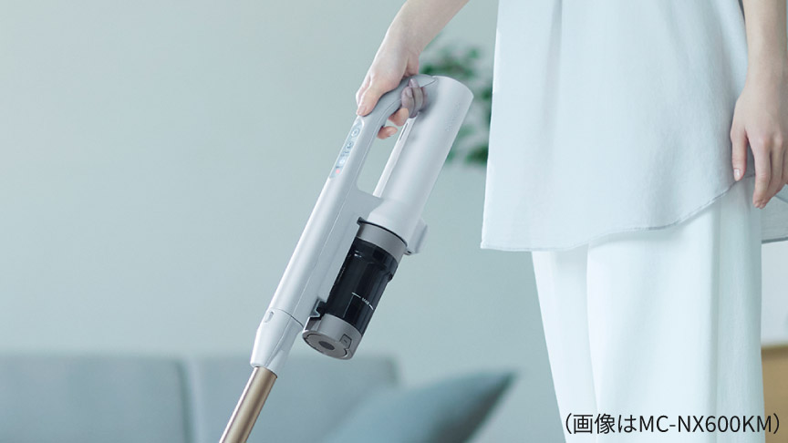 掃除機のハンドルを握っている様子