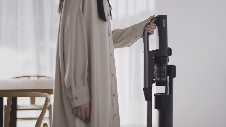 片手で掃除を持ち上げている様子