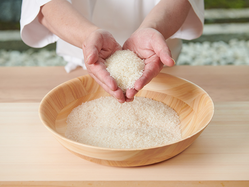 神田さんがお米をすくっている画像です。