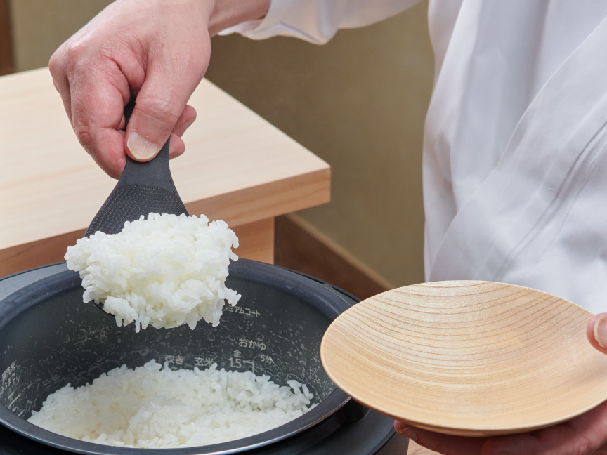 神田さんが炊いたごはんを皿によそっている画像です。