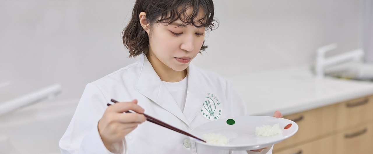 写真：皿にのせられた白米を箸でつまむようす