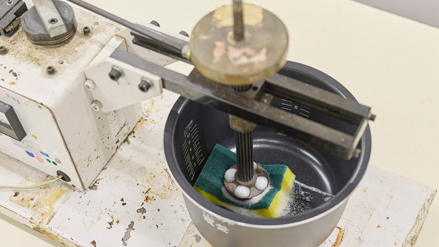 写真：炊飯器の内釜をスポンジでこするようす