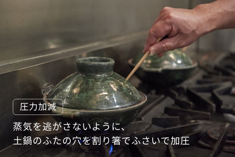 蒸気を逃がさないように、 土鍋のふたの穴を割り箸でふさいで加圧している画像です。蒸気を逃がさないように、土鍋の蓋の穴を割りばしでふさいで加圧。