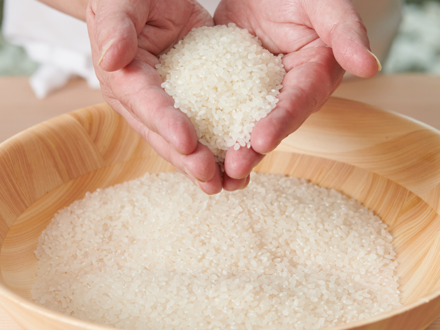 お米の状態を手ですくいながら確認している画像です。