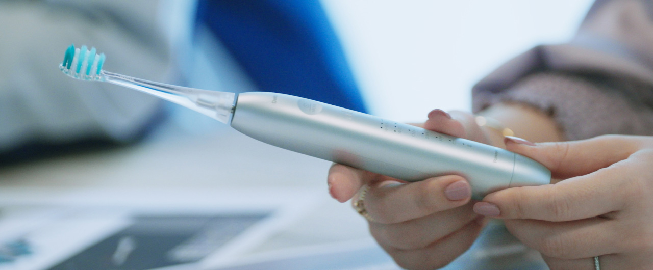 写真：ドルツプレミアムW音波振動ハブラシを手に持っている様子