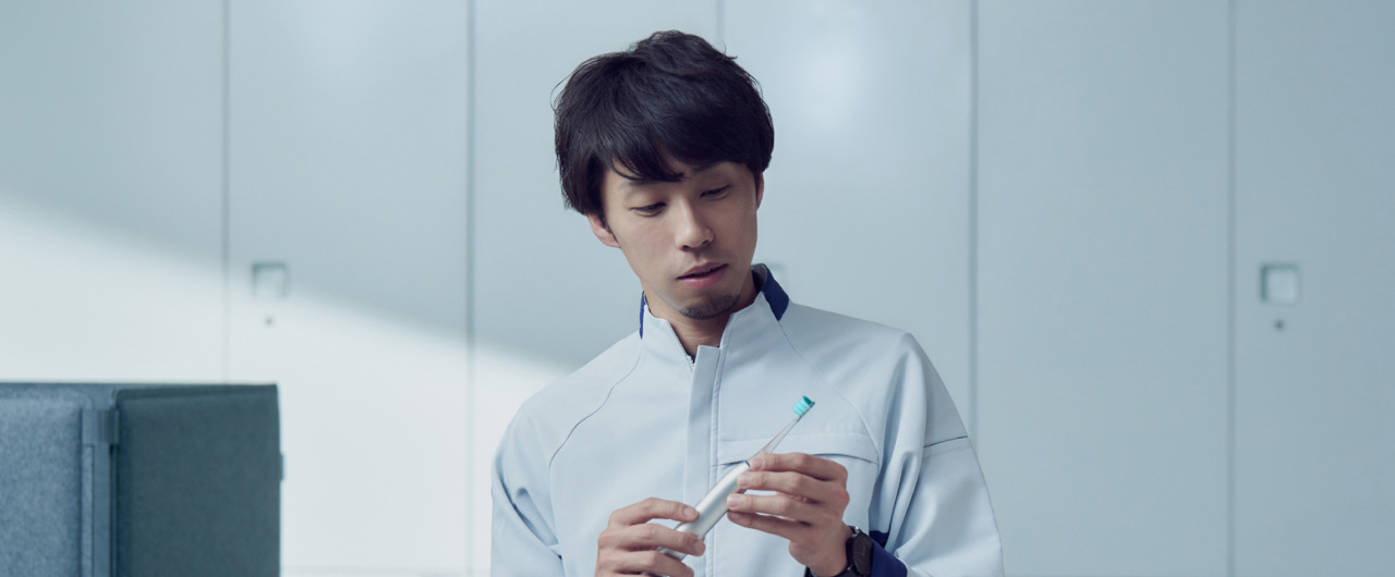 写真：中崎真太郎さんがドルツプレミアムW音波振動ハブラシを手に持っている様子