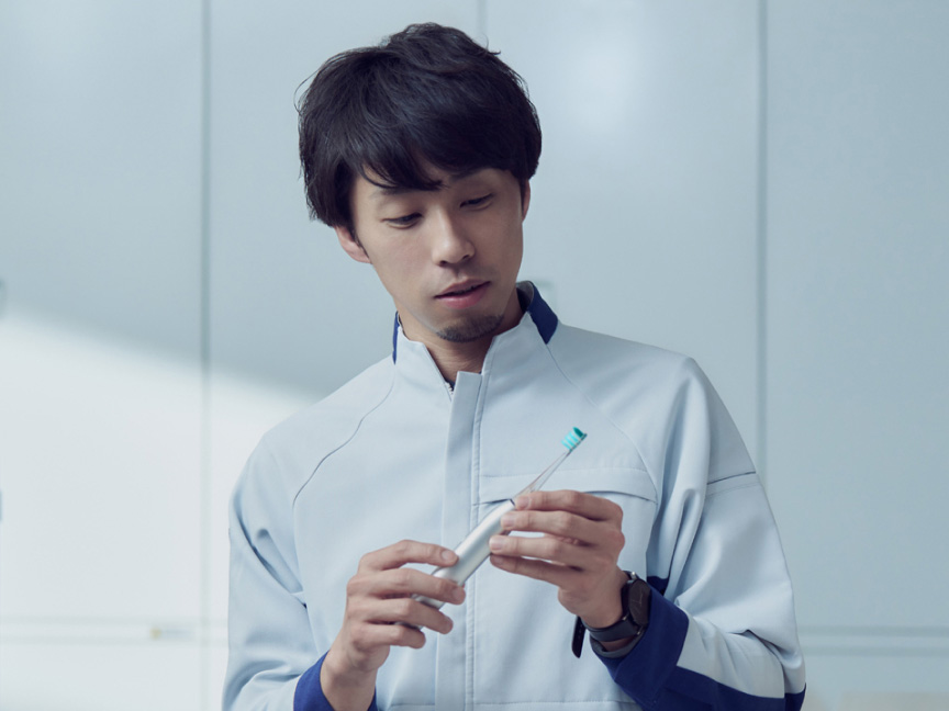 写真：中崎真太郎さんがドルツプレミアムW音波振動ハブラシを手に持っている様子