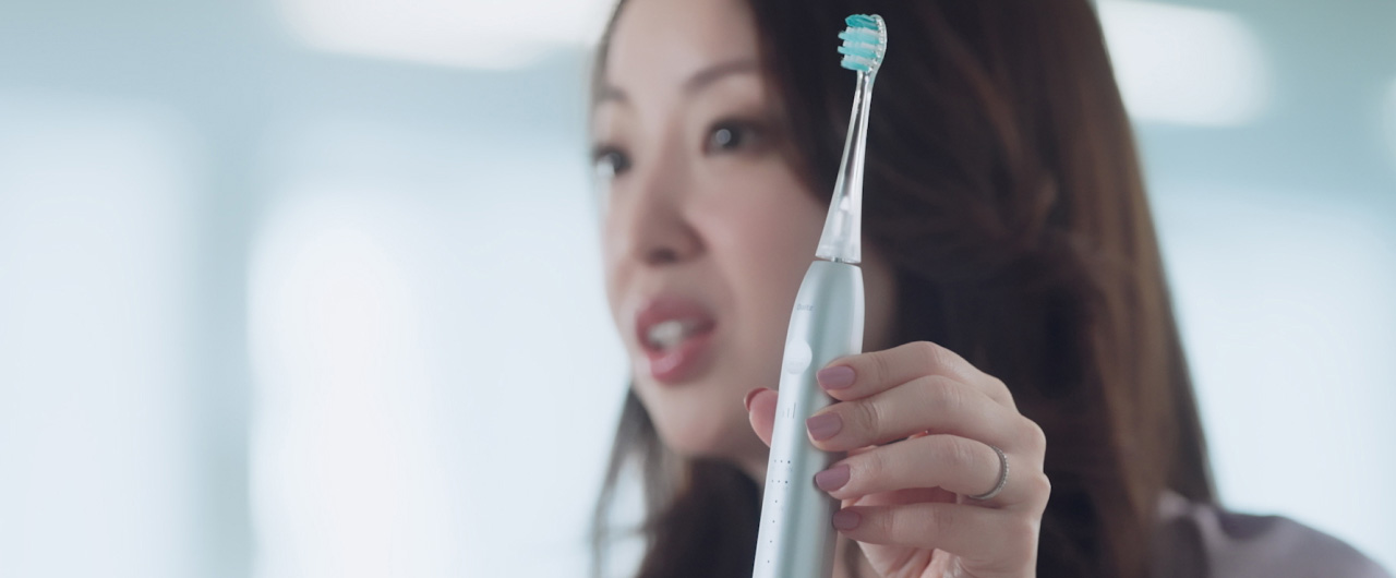 写真：光安優花さんがドルツプレミアムW音波振動ハブラシを手に持っている様子