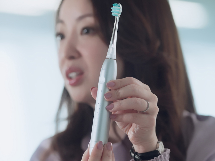 写真：光安優花さんがドルツプレミアムW音波振動ハブラシを手に持っている様子