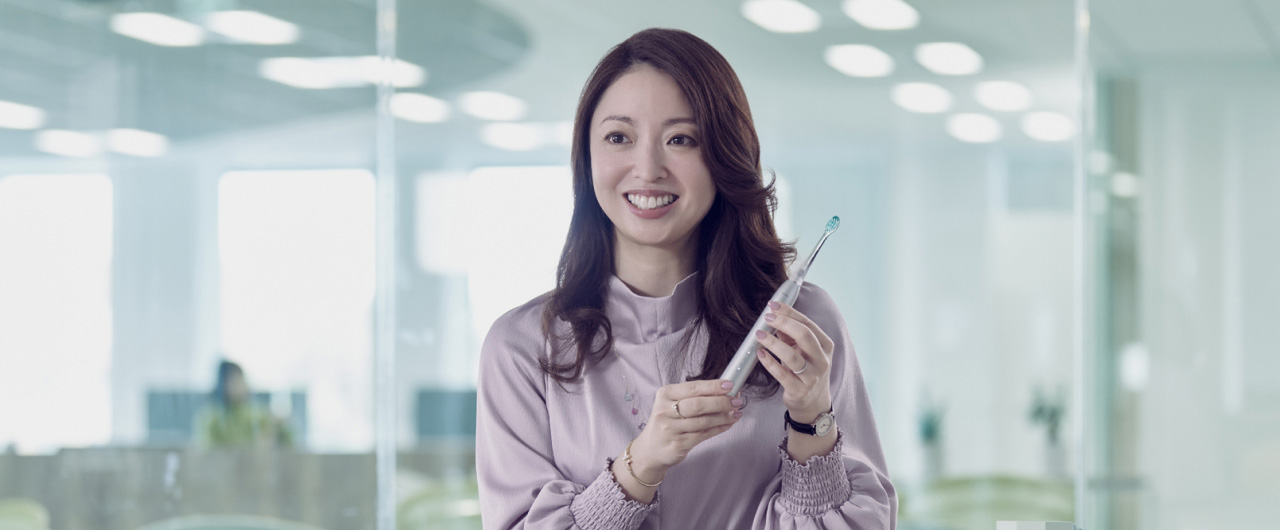 写真：光安優花さんがドルツプレミアムW音波振動ハブラシを手に持っている様子