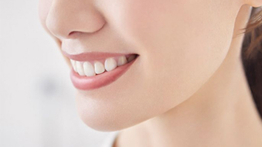 口元を写した人物の白い歯と微笑んだ横顔のクローズアップ画像