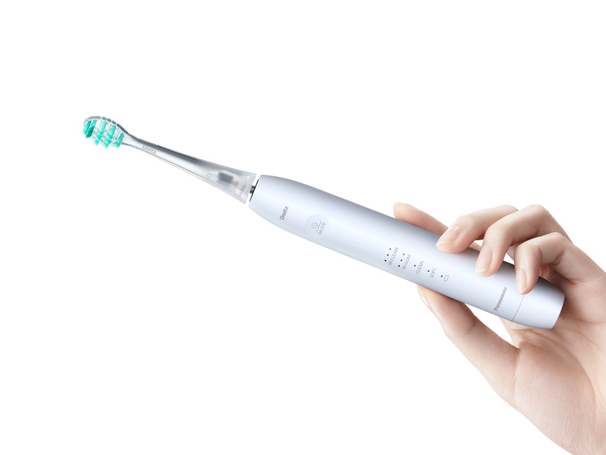 電動歯ブラシを持つ手のクローズアップ