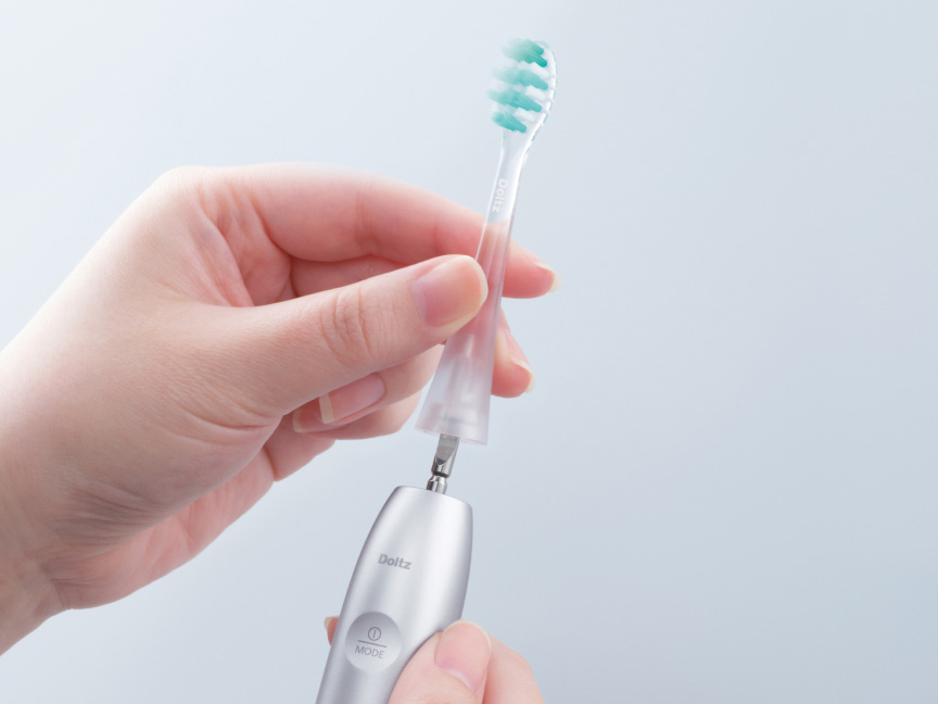 電動歯ブラシのヘッドを取り付ける様子