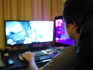 写真：オンラインゲームに打ち込む男性