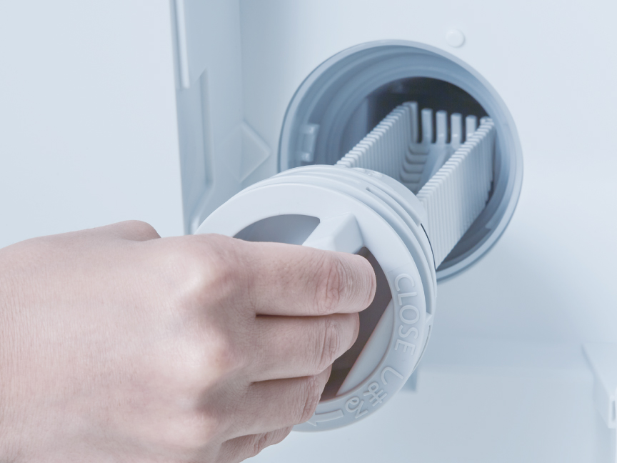 写真：排水フィルターを掃除する様子