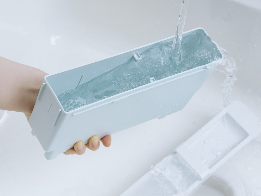 写真：自動投入タンクを水洗いする様子