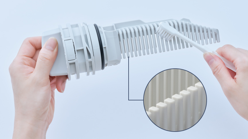 排水フィルターをブラシで掃除している様子