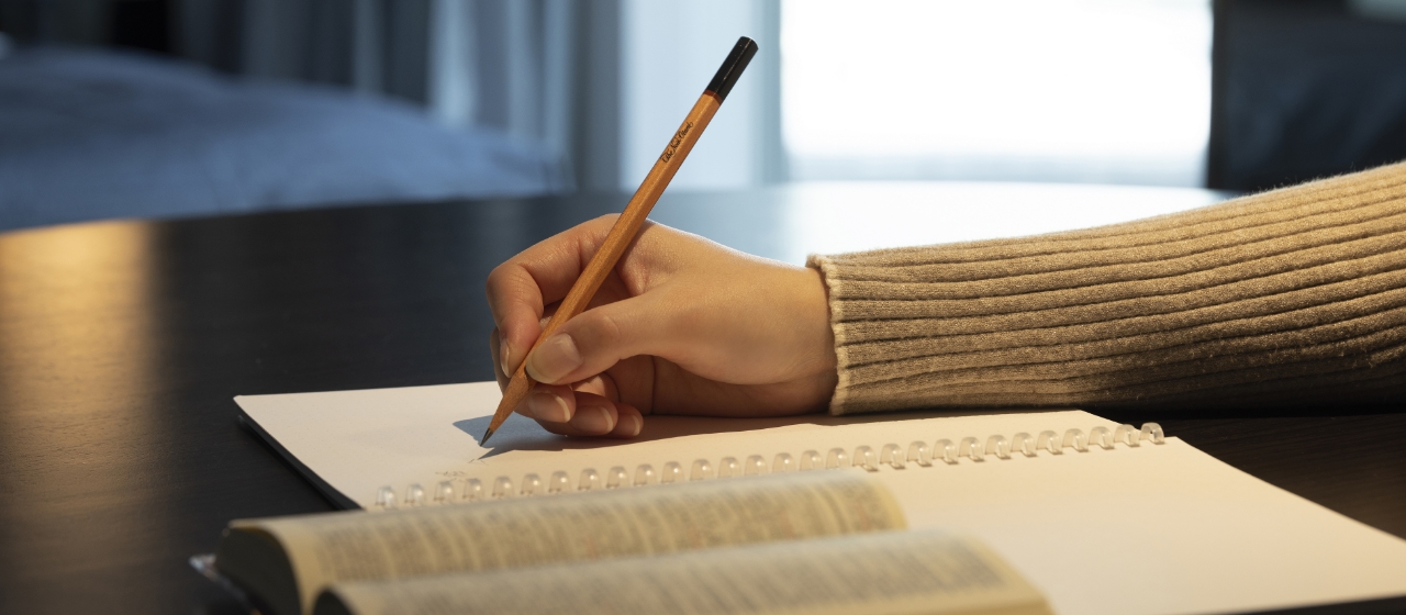 机上で受験生がノートに文字を記入している画像です