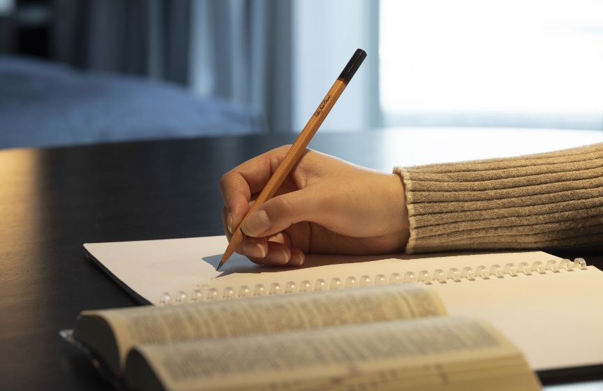 机上で受験生がノートに文字を記入している画像です