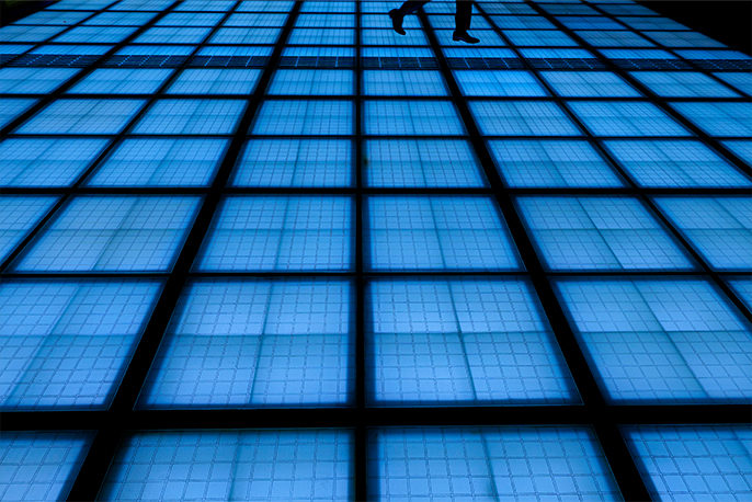 青いライトが浮かぶガラスの床