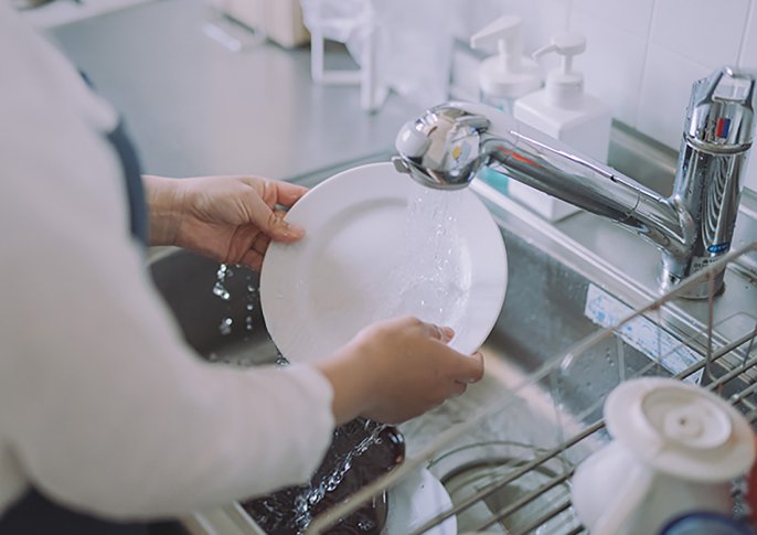 写真：キッチンシンクでお皿を洗っている様子